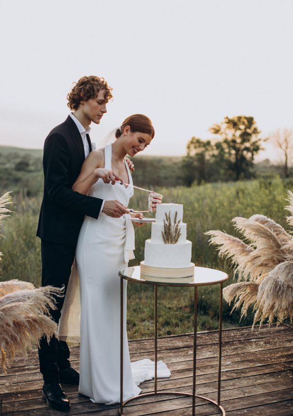 Young,Couple,Cutting,Their,Wedding,Cake